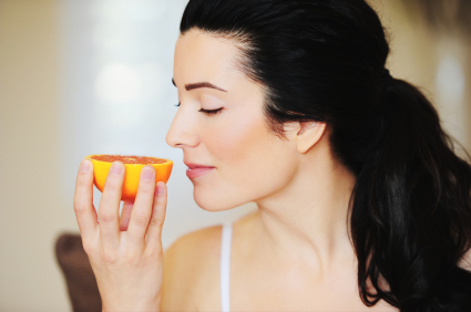 woman smelling orange